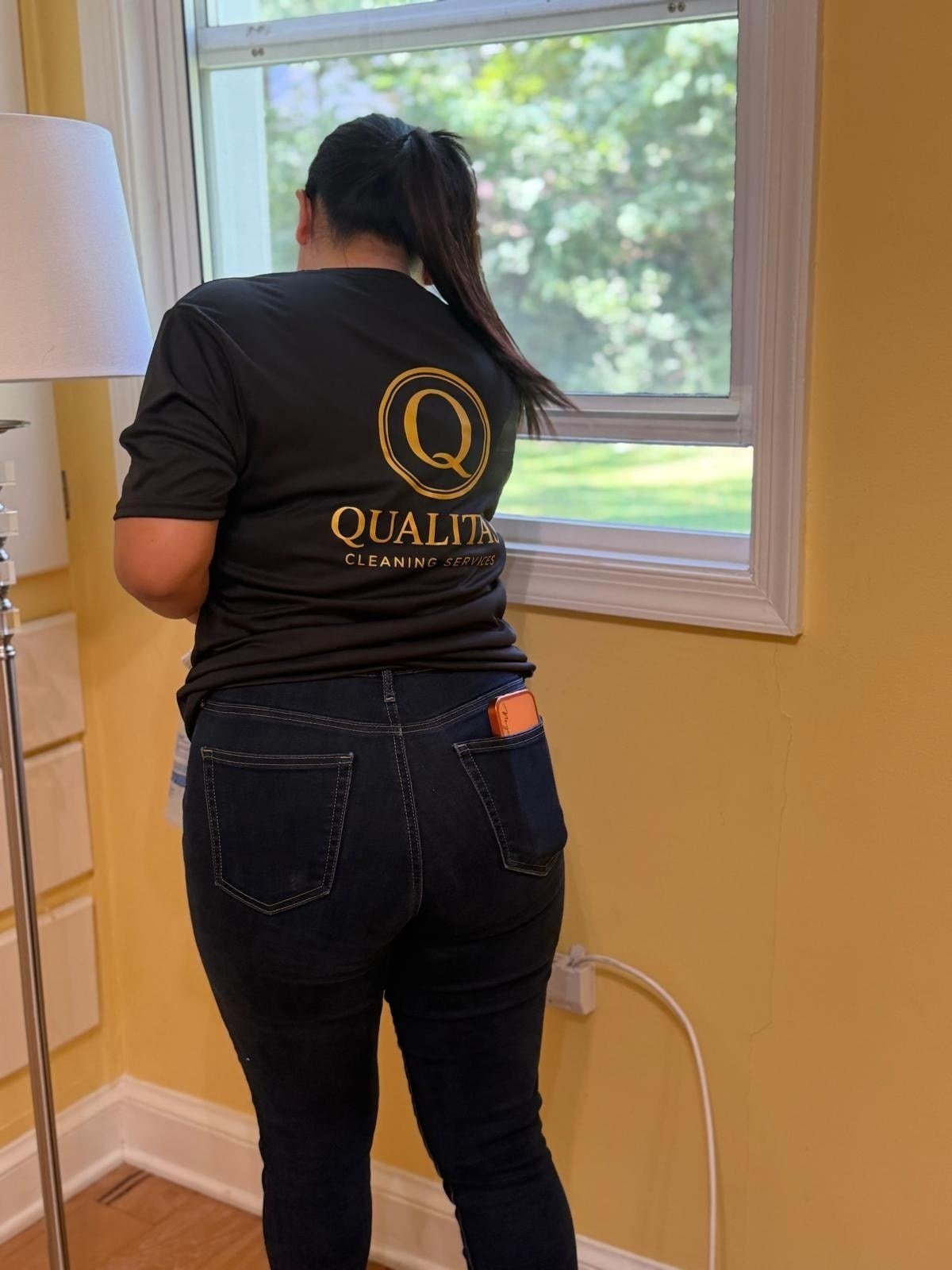 Qualitas team member cleaning a window